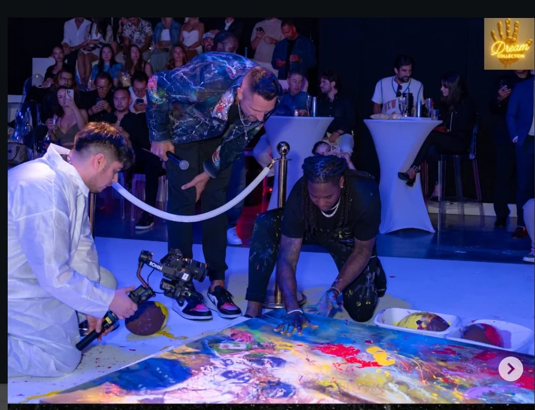 People creating collaborative art with paint at interactive event